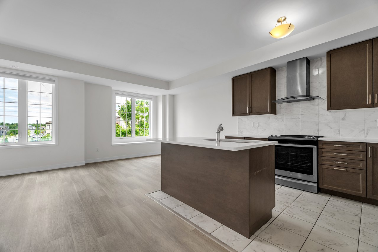 Kitchen with dark wood cabinets, a central island and garden-facing windows.